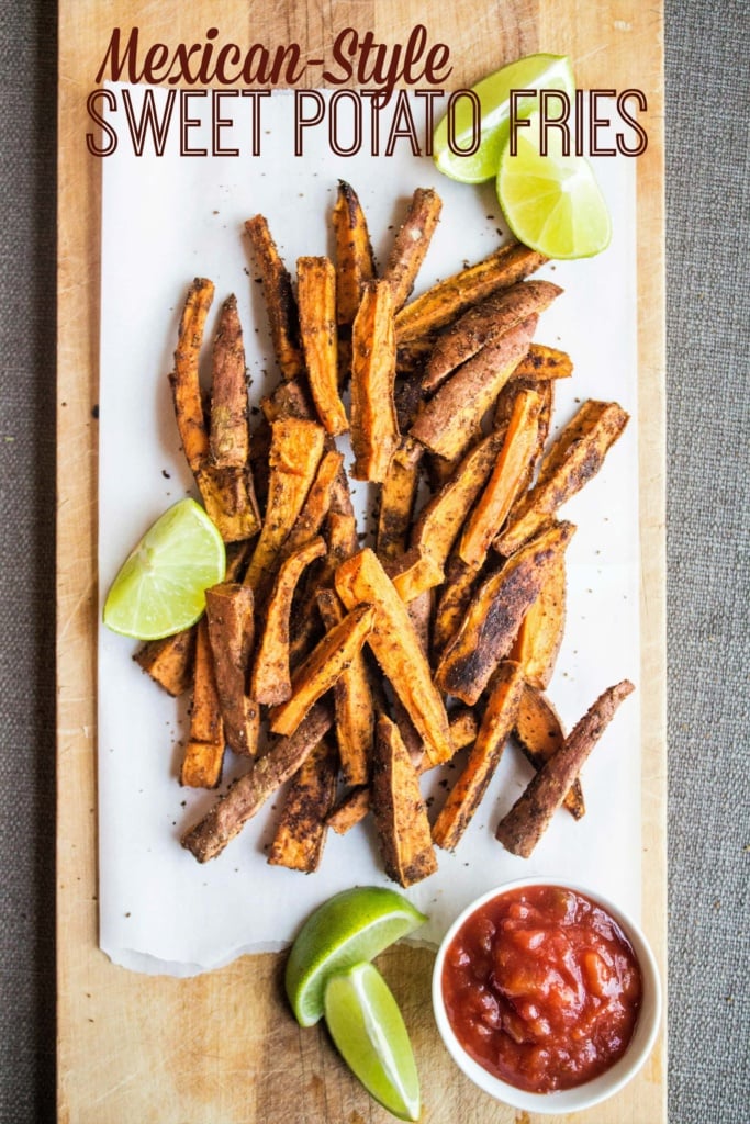 seasoned sweet potato fries on a wooden platter with lime slices and salsa