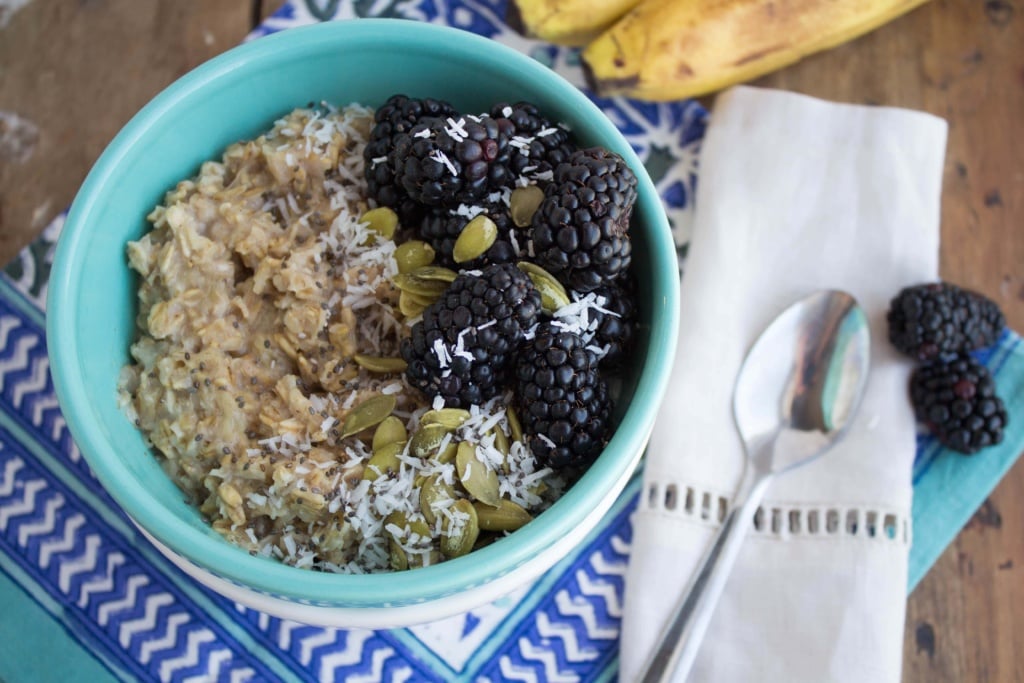 bowl of oatmeal with blackberries, bananas, and nuts