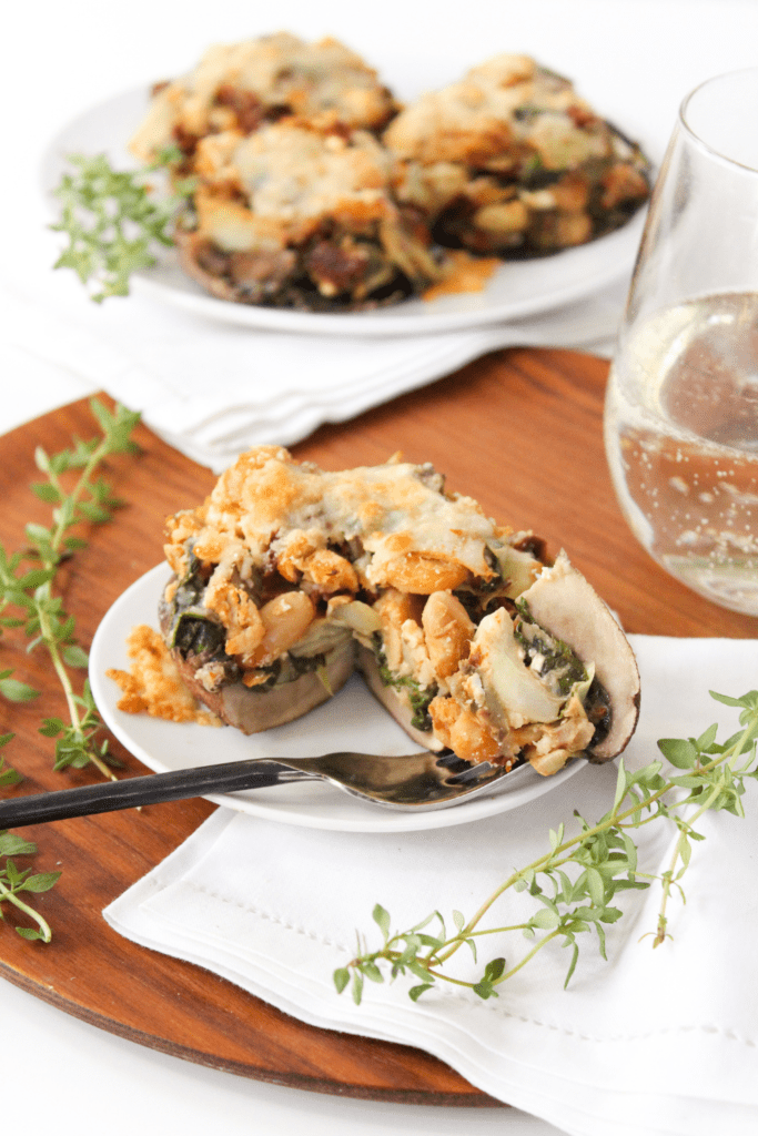 feta stuffed mushrooms with a glass of white wine in the background