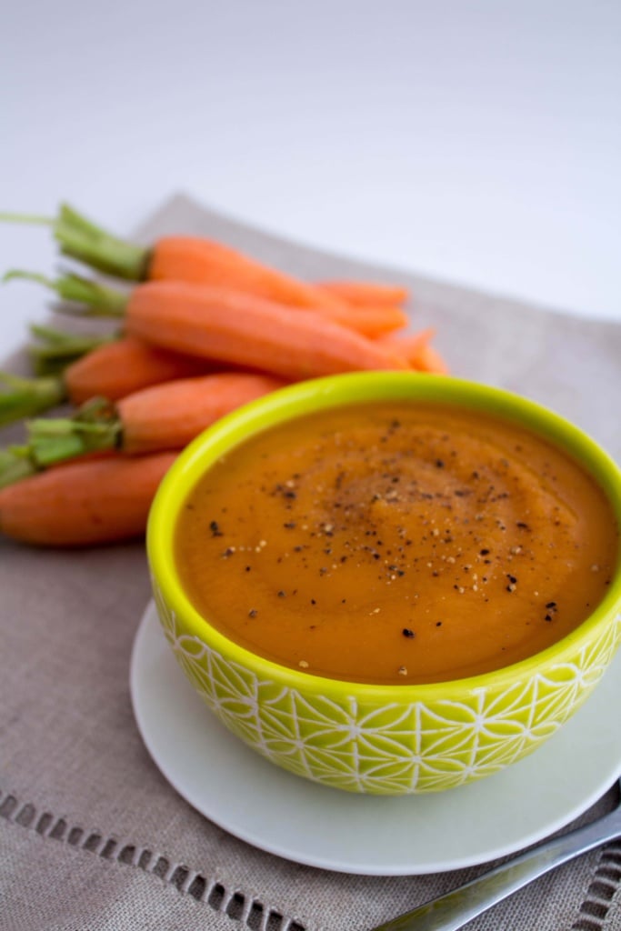 creamy vegan carrot soup with large carrots in the background