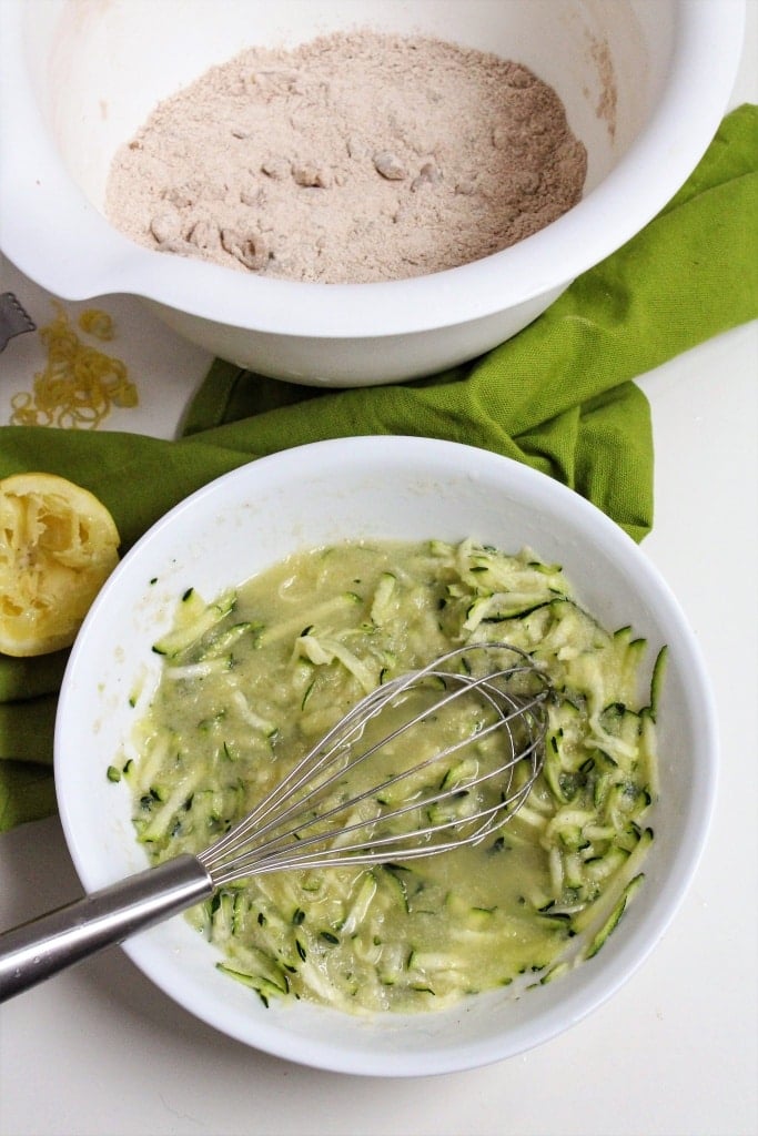 grated zucchini in a bowl with a whisk