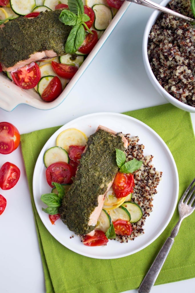 pesto salmon with squash, zucchini, and tomatoes on a dinner plate