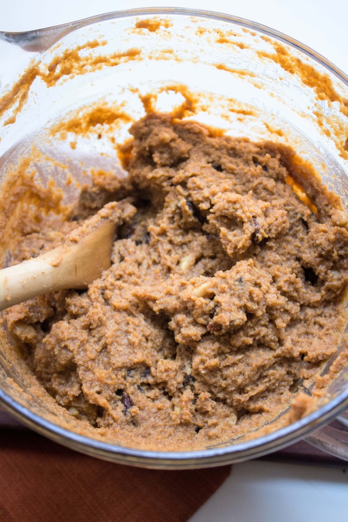 muffin batter in a large bowl with a wooden spoon