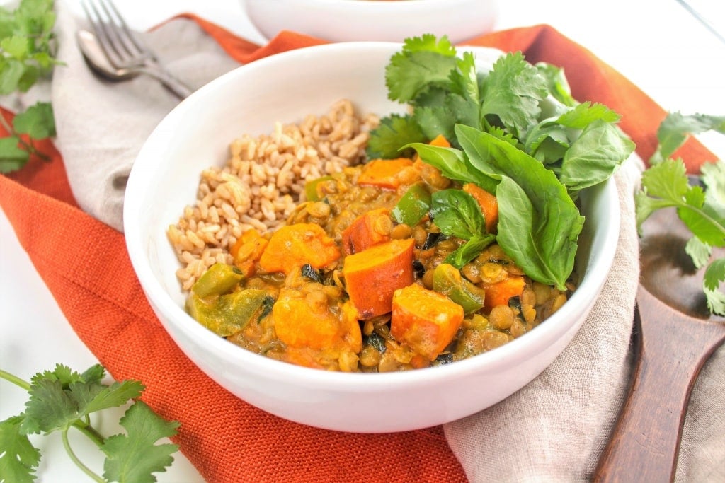 sweet potato curry in a bowl with Thai basil