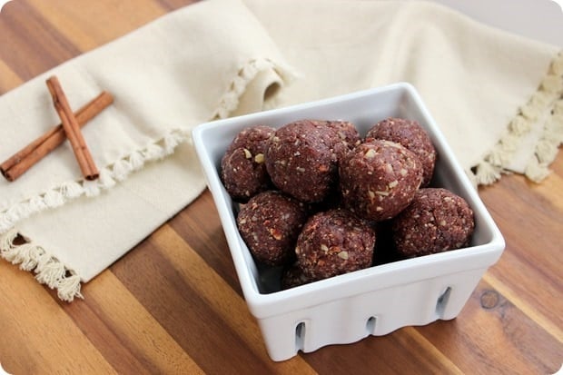 cherry pie bites in a white square container with cinnamon sticks beside them