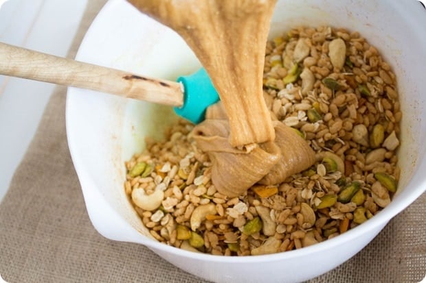 pouring peanut butter wet mixture into dry granola bar mixture
