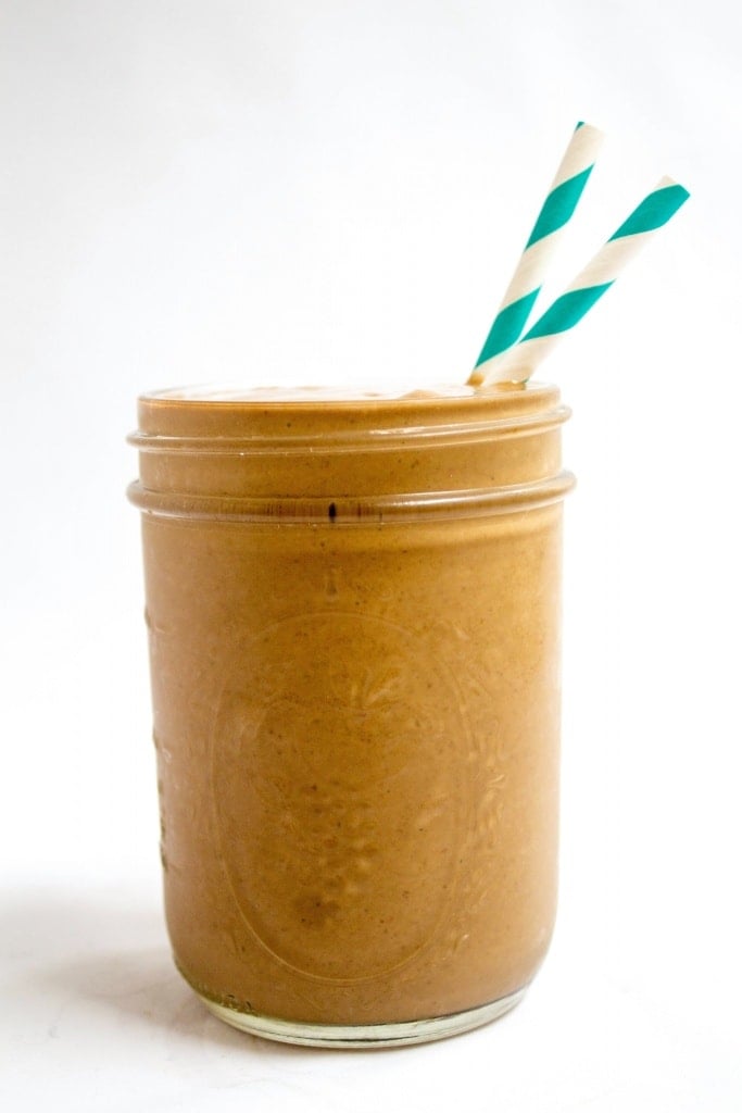 peanut butter banana smoothie with spinach in a mason jar with striped straws