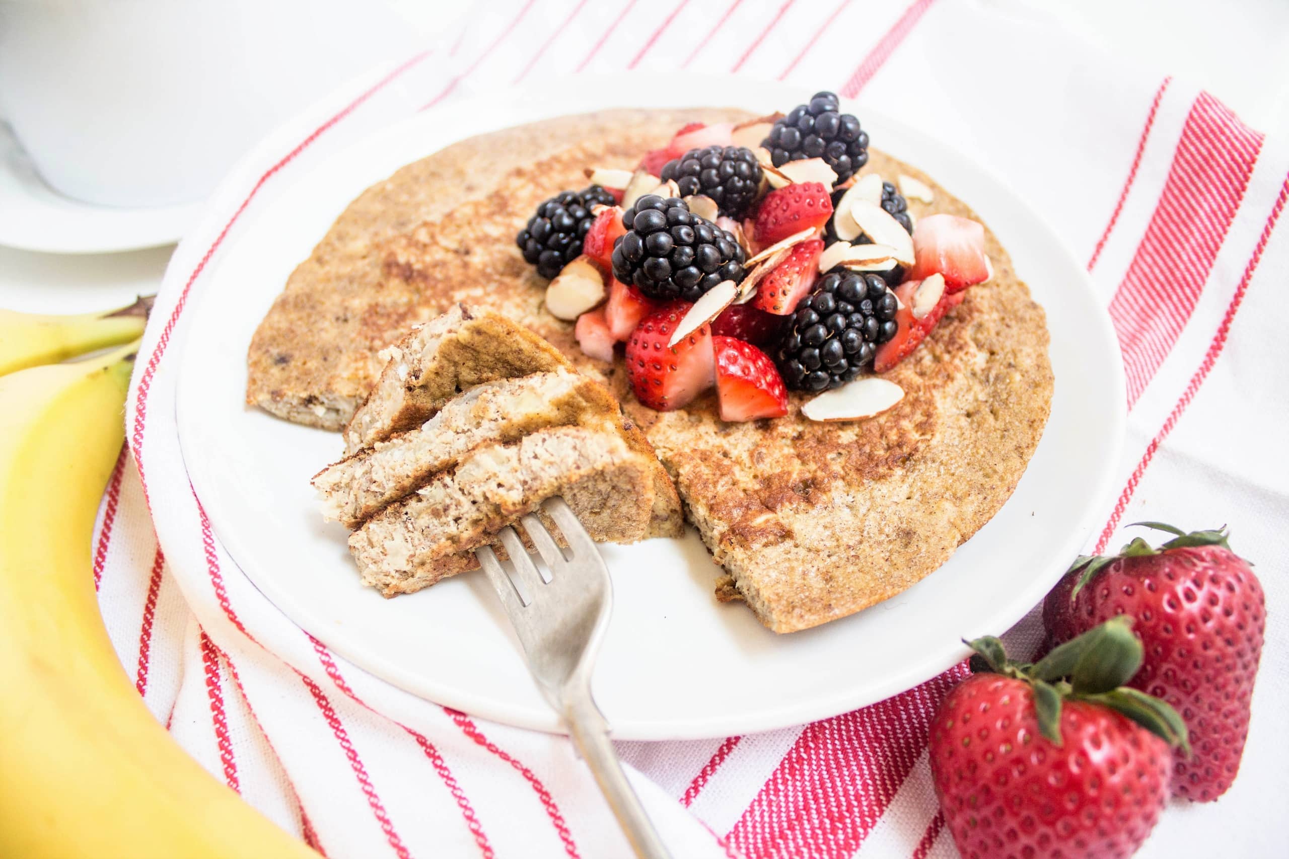banana protein pancakes with fresh berries and sliced almonds on top