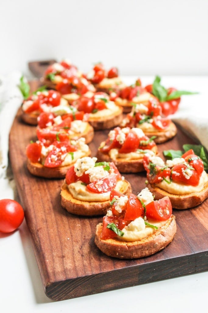 mediterranean sweet potato and hummus bites on a wooden serving board