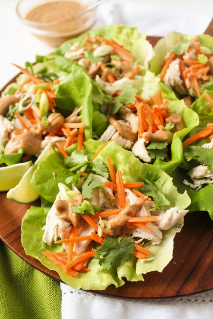 close up of chicken lettuce wraps on a wooden platter