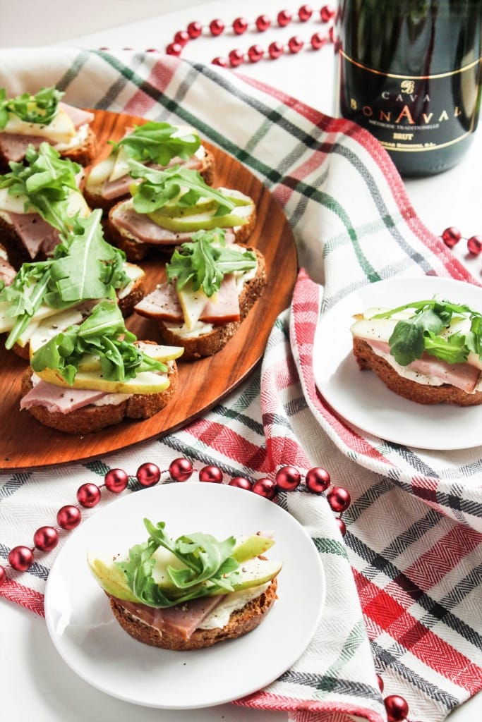 Ham and Pear Crostini on a red and green striped white kitchen towel