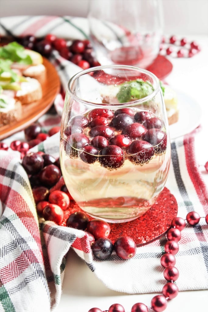 Cava sparkling wine in a stemless glass with cranberries