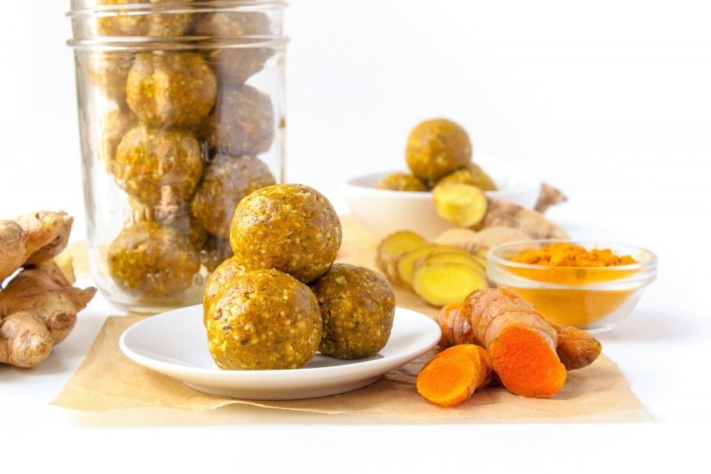 no bake turmeric ginger energy balls stacked on a small white plate