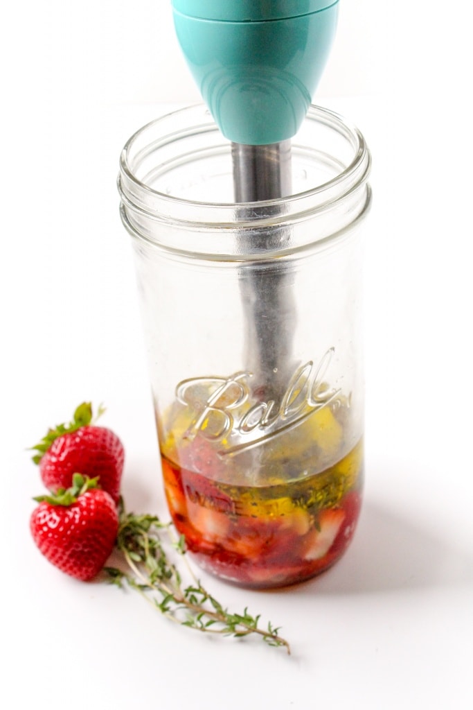 diced strawberries, apple cider vinegar, olive oil, herbs, and garlic in a mason jar with an immersion blender