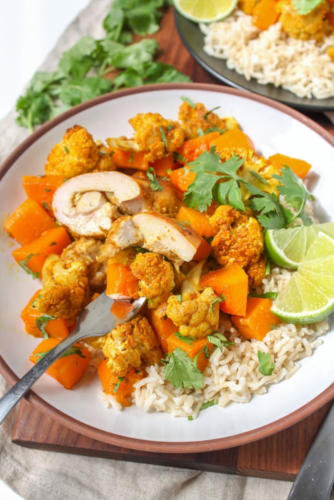 baked maple curry chicken on a plate with rice and vegetables