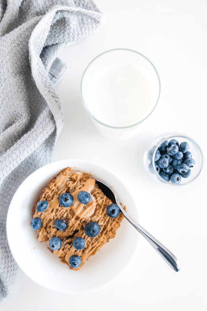 oatmeal in a white bowl with blueberries in a small jar