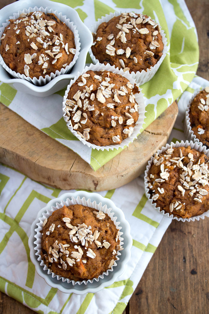 carrot cake muffins on a white and green kitchen towel