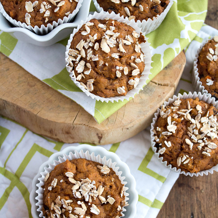 carrot cake muffins in a white and green kitchen towel