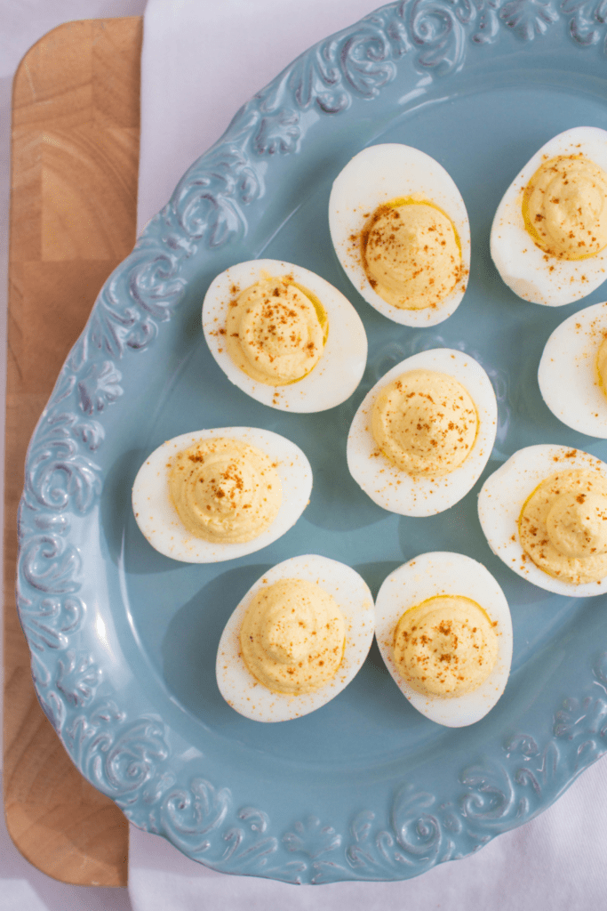 deviled eggs with paprika on a blue platter