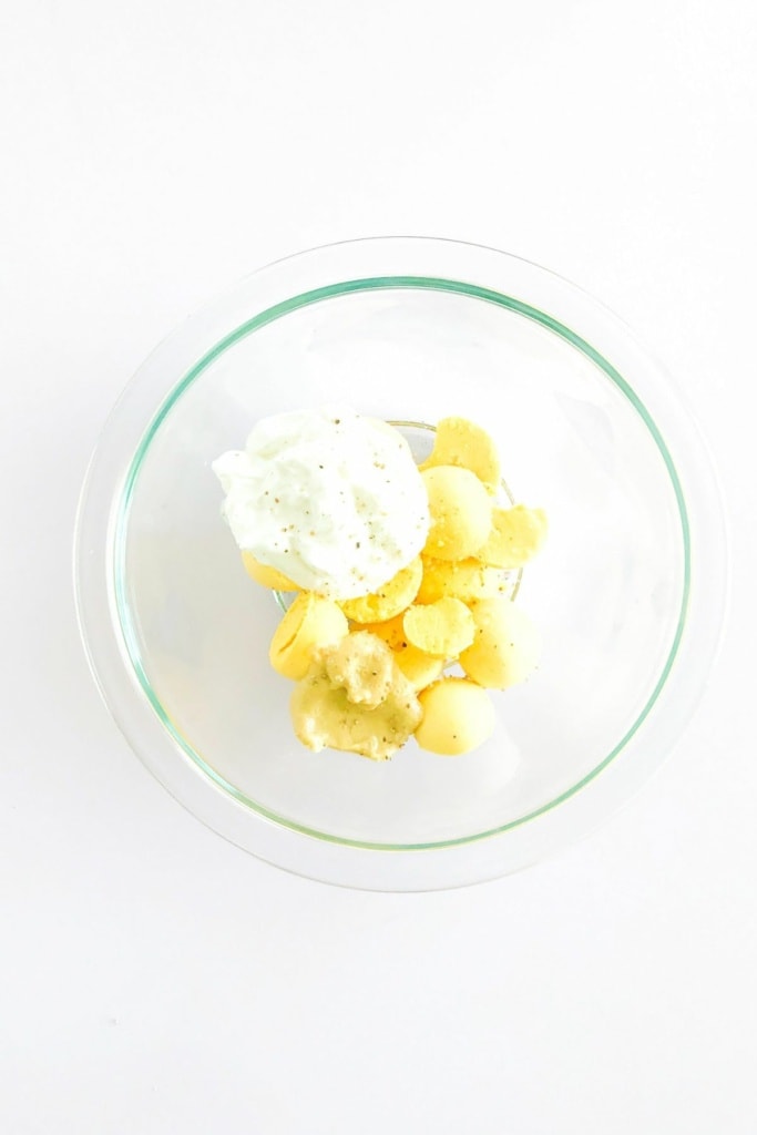 cooked egg yolks in a glass bowl with Greek yogurt
