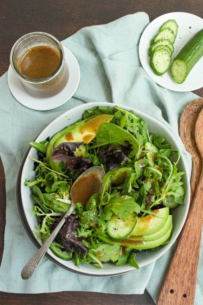 simple green salad in a bowl with wooden salad spoons