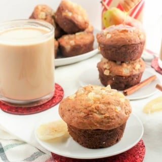 ginger pear muffins on a plate with a glass of milky tea in the background