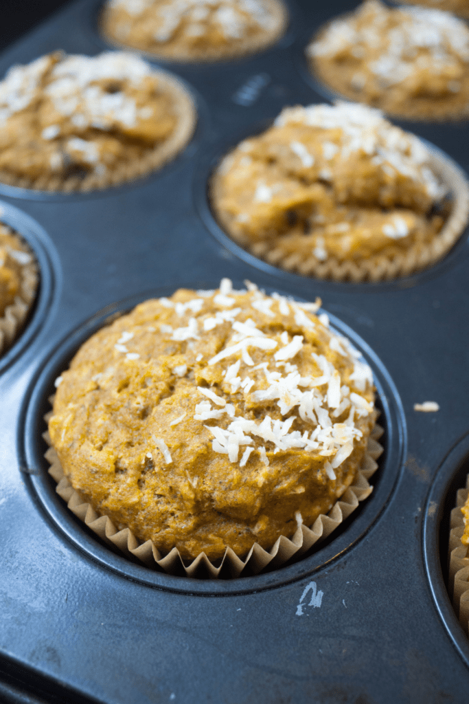 muffins topped with shredded coconut in a muffin tin