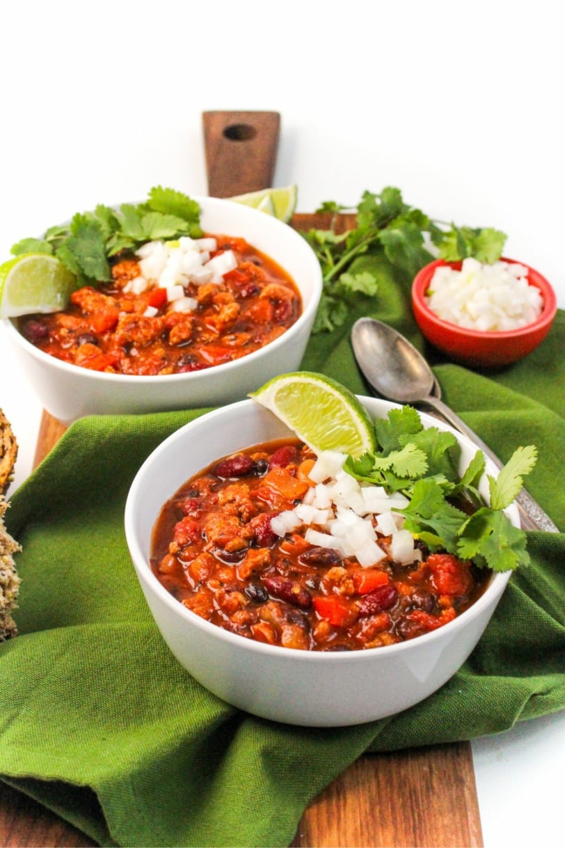 chili in a bowl with diced onion and cilantro on top