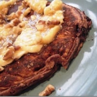 Pomegranate Blueberry Pancakes with walnuts, bananas, and maple syrup topping