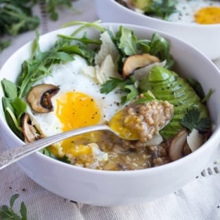 savory oatmeal with egg in a bowl with mushrooms and avocado