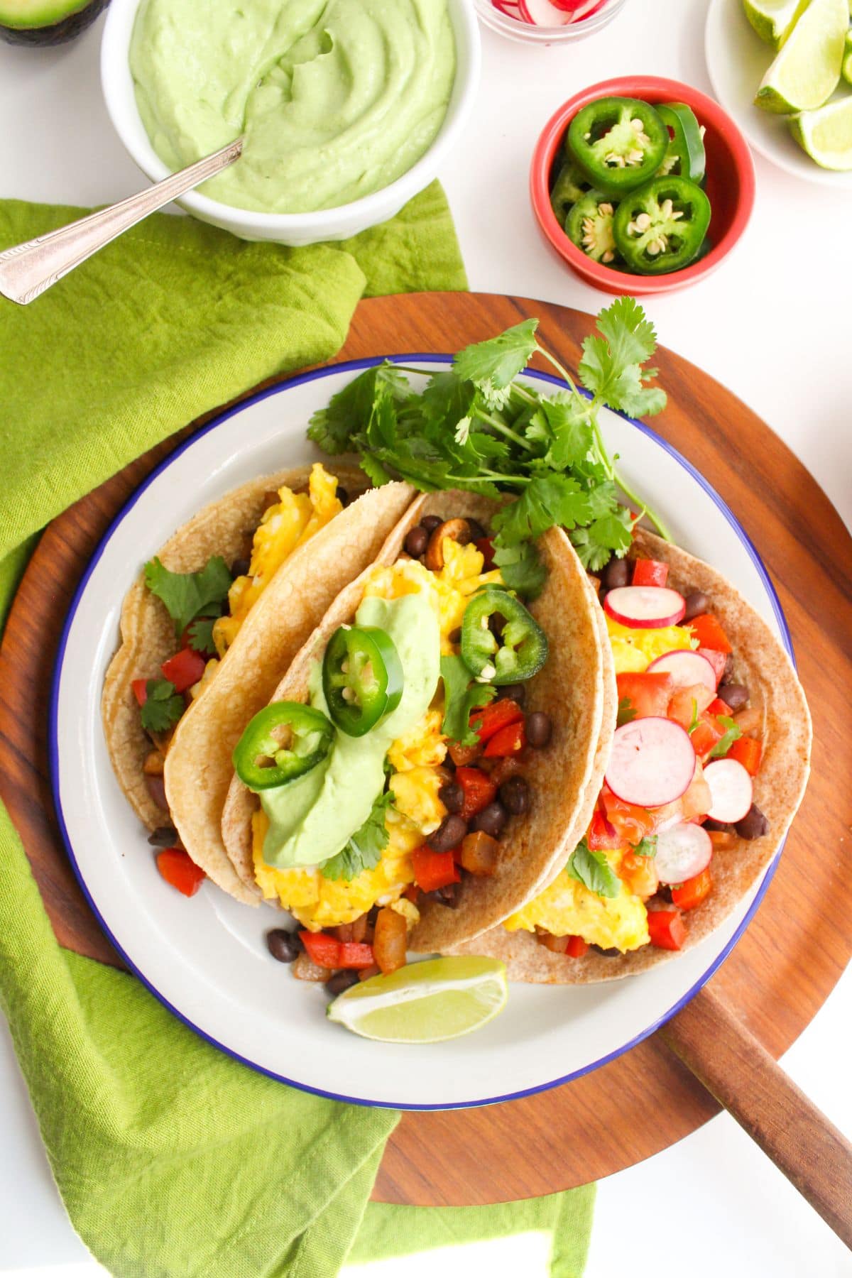egg tacos with vegetables, black beans, and avocado crema