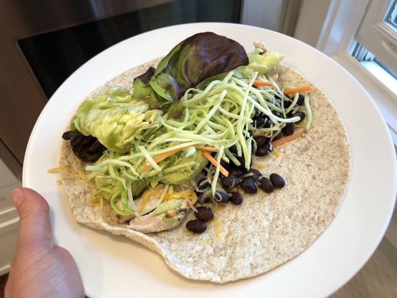 wrap with chicken, black beans, cheese, broccoli slaw, guacamole, and lettuce