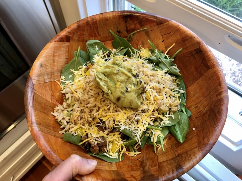 taco salad with greens, cheese, guacamole, ground beef, cilantro, and black beans