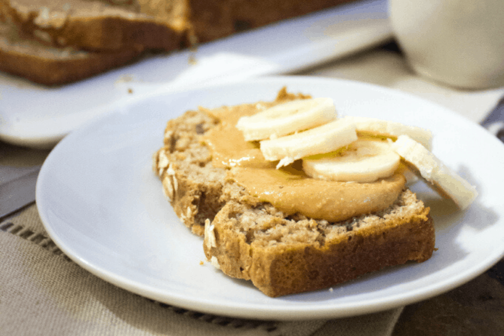 slice of whole wheat peanut butter banana bread on a white plate