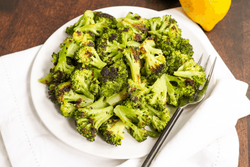 roasted broccoli on a plate with lemons