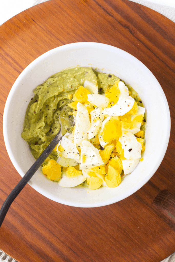 hard-boiled eggs in a bowl with avocado and dijon mustard