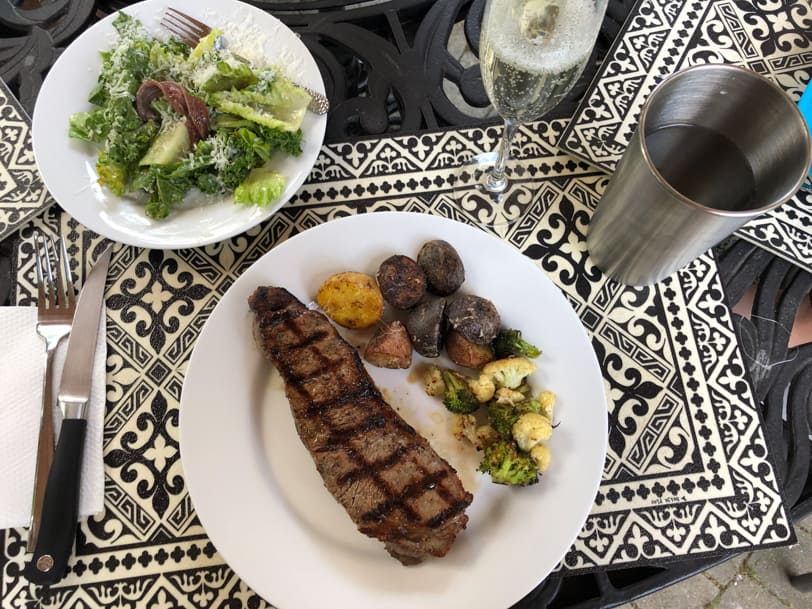 steak with roasted potatoes, roasted cauliflower and broccoli, and caesar salad