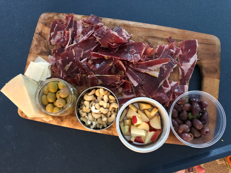 appetizer plate with olives, cashews, apple, and ham