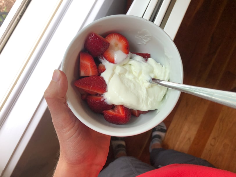 a bowl of yogurt and sliced strawberries