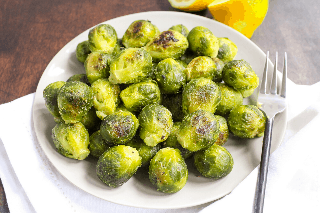 roasted brussels sprouts from frozen on a white plate with lemons