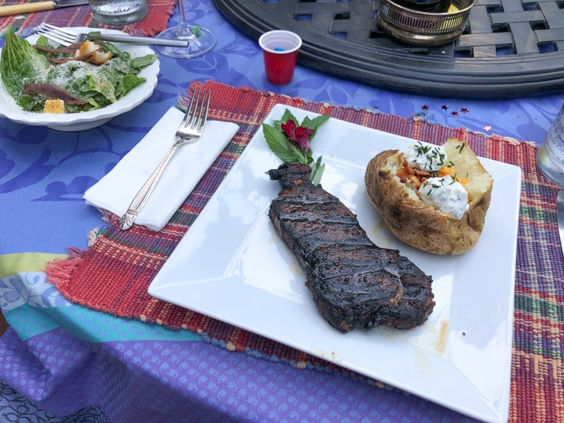 steak with baked potatoes and caesar salad