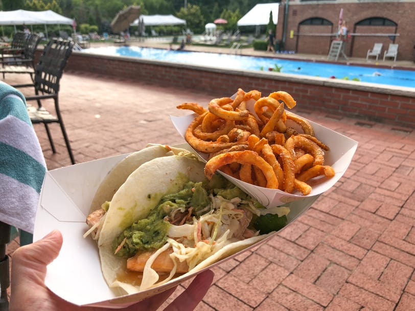salmon tacos and curly fries with a view of the pool