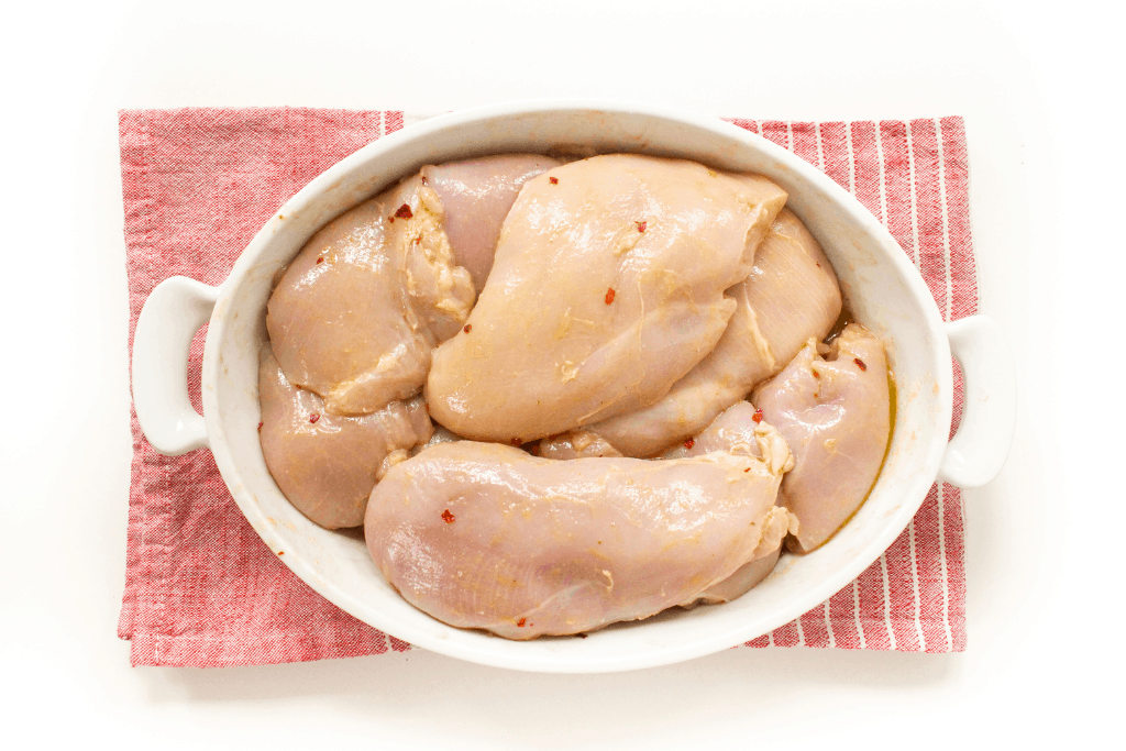 chicken and marinade in a white dish