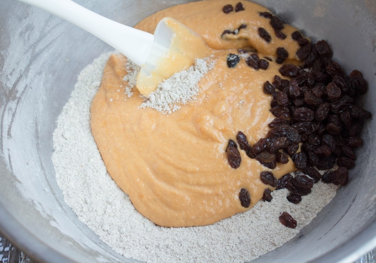 pumpkin muffin ingredients combined in a bowl with a spatula
