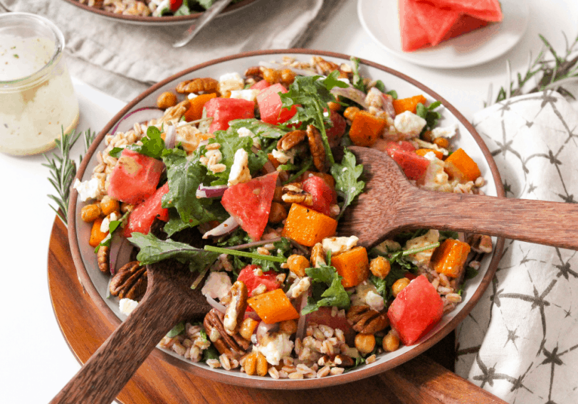 salad with watermelon and butternut squash, with wooden spoons for serving