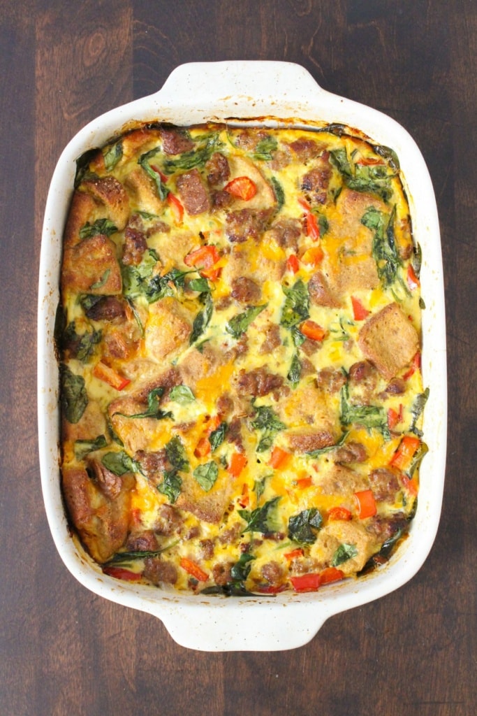 baked breakfast casserole with sausage and vegetables in a white dish