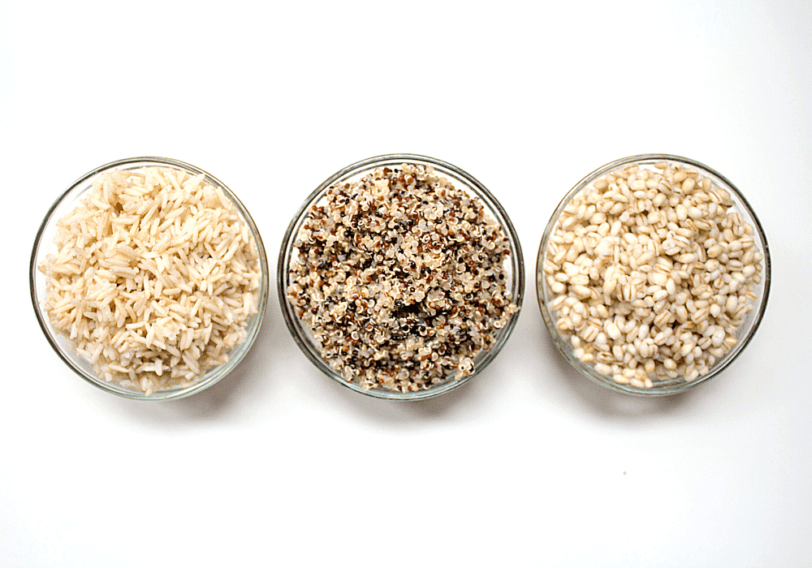 cooked brown rice, quinoa, and barley in small glass bowls