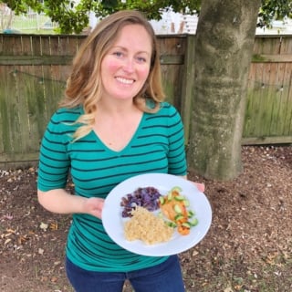 anne holding plate of blue apron salmon