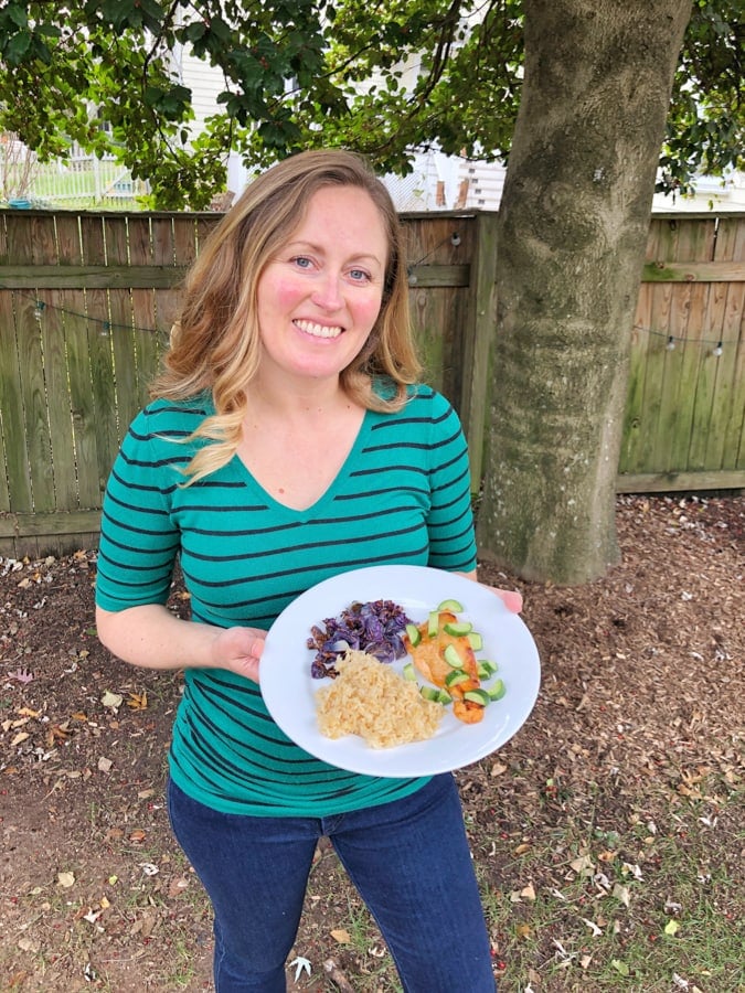 anne holding plate of blue apron salmon