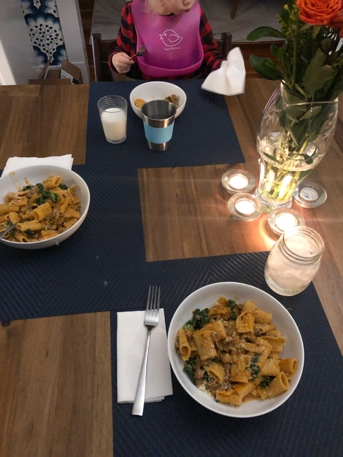 kale and sausage rigatoni dinner with candles